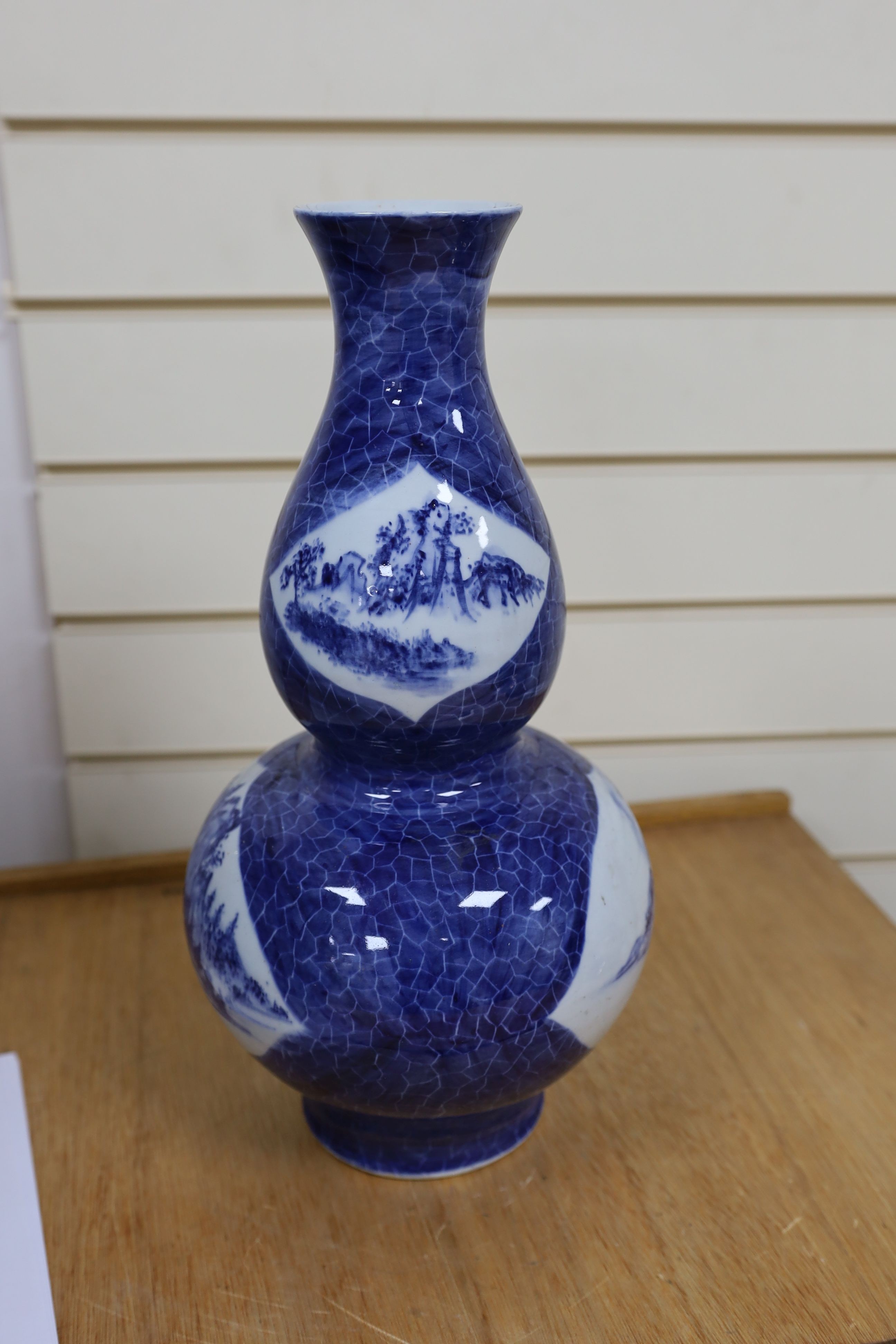 A Chinese blue and white gourd vase with landscape decoration, a similar blue and white sleeve vase and a Japanese Kutani vase